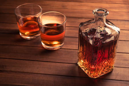 Glass and bottle with whiskey on wood backgroundの写真素材