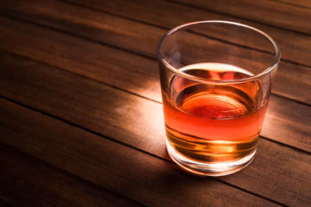 Glass with cognac on wood tableの写真素材