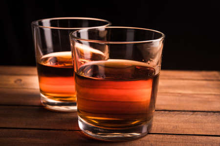 Glasses of whiskey on wooden tableの写真素材