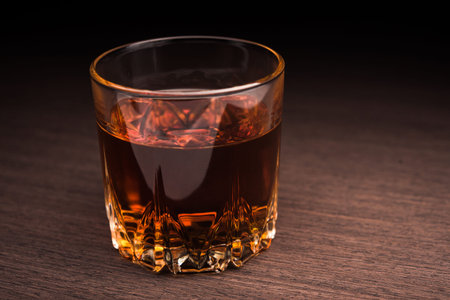 Glass of cognac on background