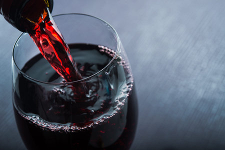 Wine spill in glass on dark backgroundの写真素材