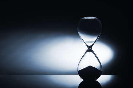 Hourglass clock on dark backgroundの写真素材