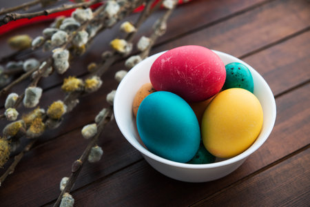 Easter eggs and willow tree on wood table