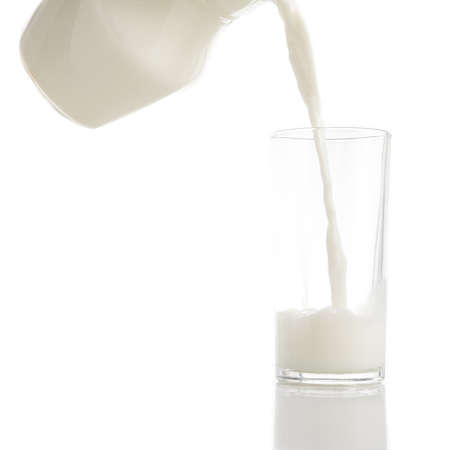 Pouring frsh milk into glass isolated on white backgroundの写真素材