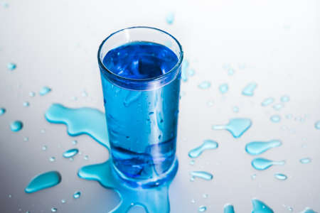 Glass of cold water and splashes on white backgroundの写真素材