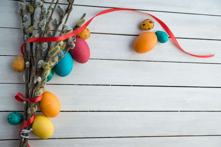 Easter eggs and willow tree on white wood tableの写真素材