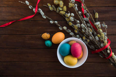 Easter eggs and willow tree on white wood tableの写真素材