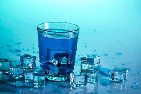 Glass with water on blue backgroundの写真素材