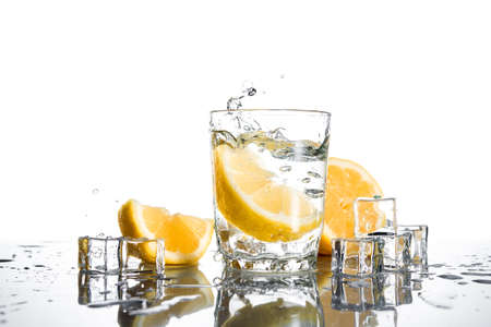 Fresh lemons in water glass isolated on white backgroundの写真素材