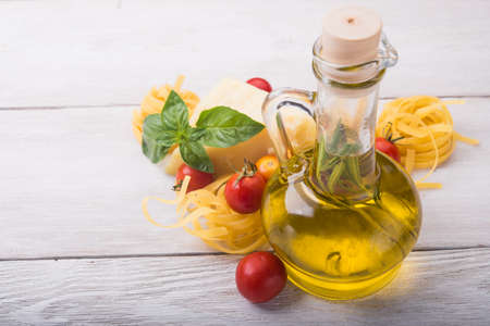 raw pasta, green basil and chesse on woode ntableの写真素材