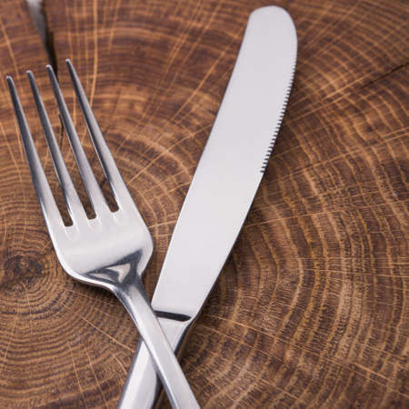 metal fork and knife on wooden tableの写真素材