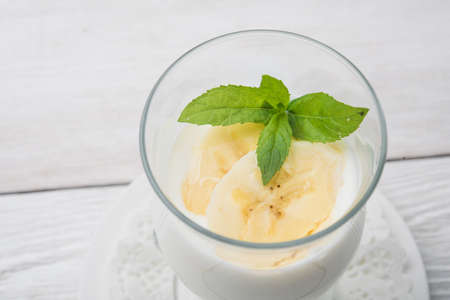 banana cocktail with green mint on white wooden tableの写真素材