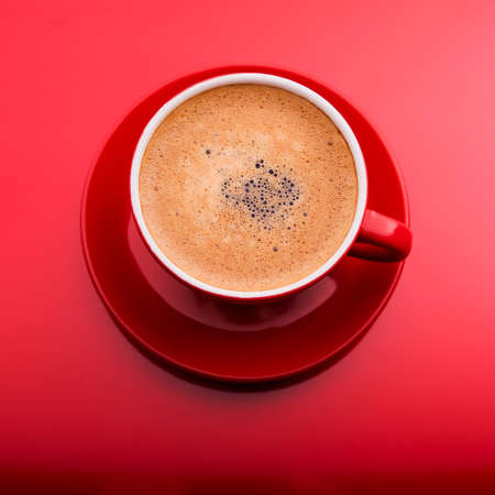 Cup of cappuccino on red backgroundの写真素材