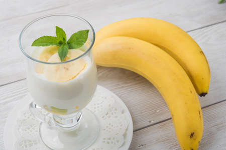 banana cocktail with green mint on white wooden tableの写真素材