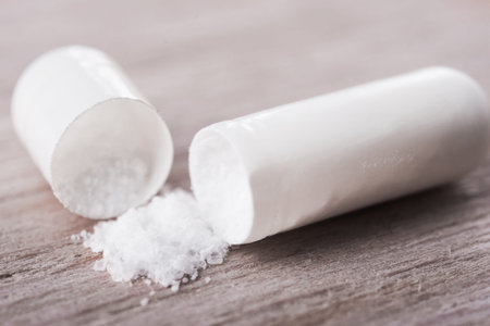 Close up of open pill with pile drug on background