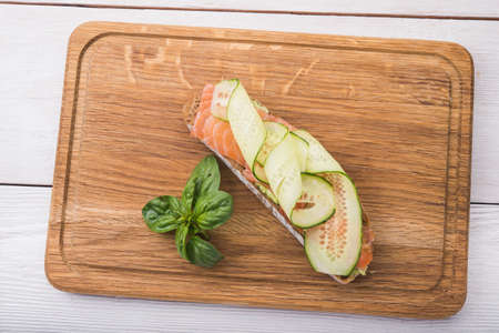 bruschetta with salmon and cucumber on wooden boardの写真素材