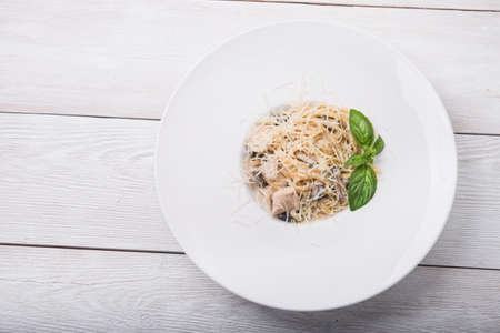 pasta with chicken and mushrooms on white plate backgroundの写真素材