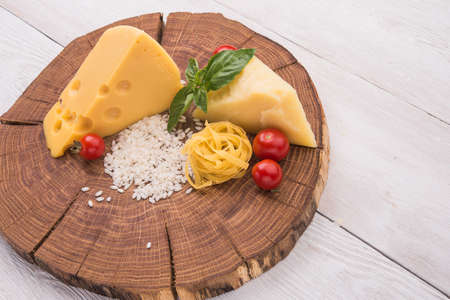 raw pasta, green basil and chesse on woode ntableの写真素材