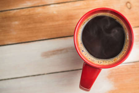 red coffee cup on wood tableの写真素材
