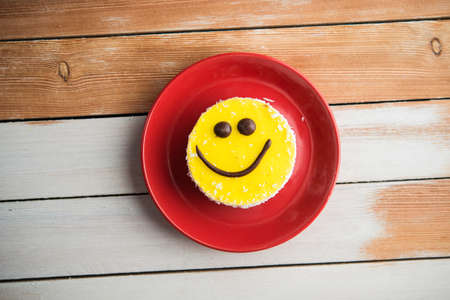 round cake in the form of smiley with chocolate dropsの写真素材