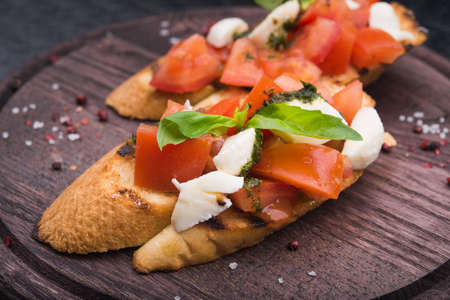bruschetta with tomato and mozzarella on wood boardの写真素材