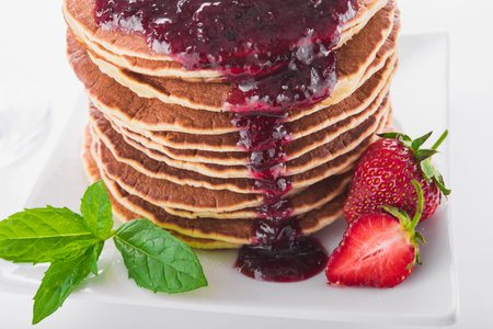sweet breakfast of pancakes and strawberries on white background