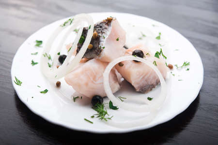fresh herring fish with spices on white plateの写真素材