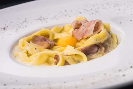 pasta carbonara with raw egg in white dishの写真素材