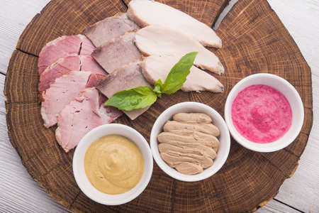 ham meat with three sauces on wood tableの写真素材