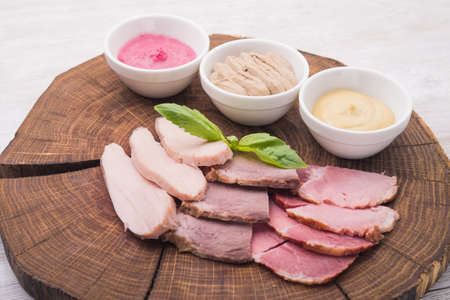 ham meat with three sauces on wood tableの写真素材