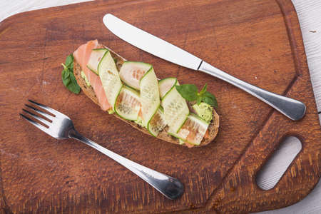 bruschetta with salmon and cucumber on wooden boardの写真素材