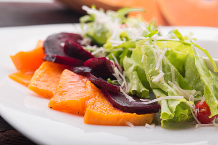 fresh salad with pumpkin and beetroot on white plateの写真素材