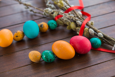 Easter eggs and willow tree on background