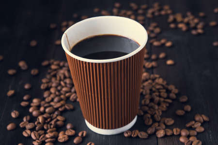 paper cup of hot coffee on wooden tableの写真素材