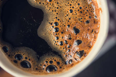 paper cup of hot coffee on wooden tableの写真素材