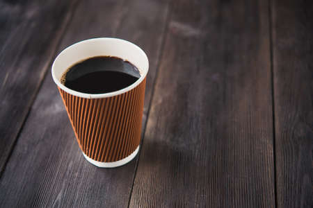 paper cup of hot coffee on wooden tableの写真素材
