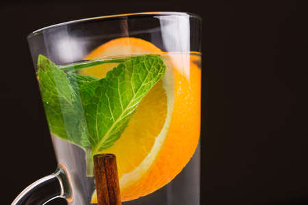 cup of tea with cinnamon, mint and orangeの写真素材