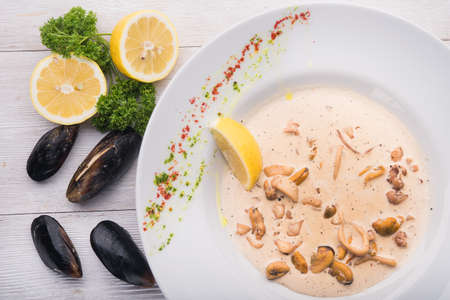 ready mussels in white dish on wooden tableの写真素材
