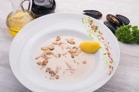 ready mussels in white dish on wooden tableの写真素材