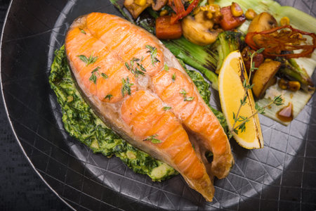 salmon steak on metal pan with vegetablesの写真素材