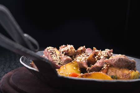fried potatoes with meat veal on metal panの写真素材