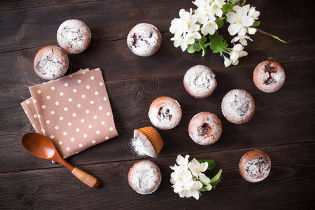 spring background with tasty cakes and blossom flowers on brown color wood tableの写真素材