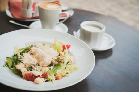A light breakfast with a caesar salad and a cup of coffee