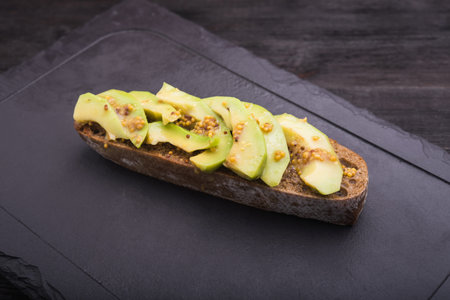 tasty avocado bruschetta on black background