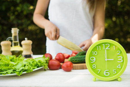 Watches clock are on the table where the woman preparing salad. food background.