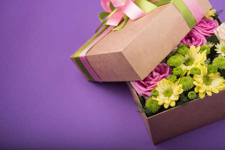Gift box with flowers on purple backgroundの写真素材