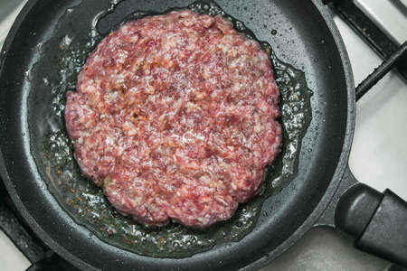 big and juicy burger cutlet on metal panの写真素材