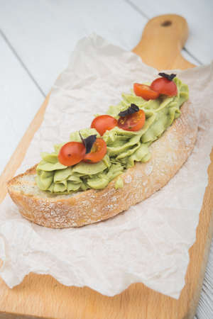 bruschetta with cream and tomatoes on a white tableの写真素材