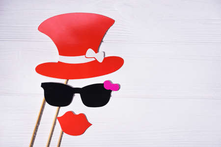 funny faces created from wedding props glasses, mustache and hat, lips on wood tableの写真素材