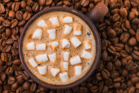vintage coffee cup with hot dring and tasty marshmallow, roasted beans on wooden tableの写真素材